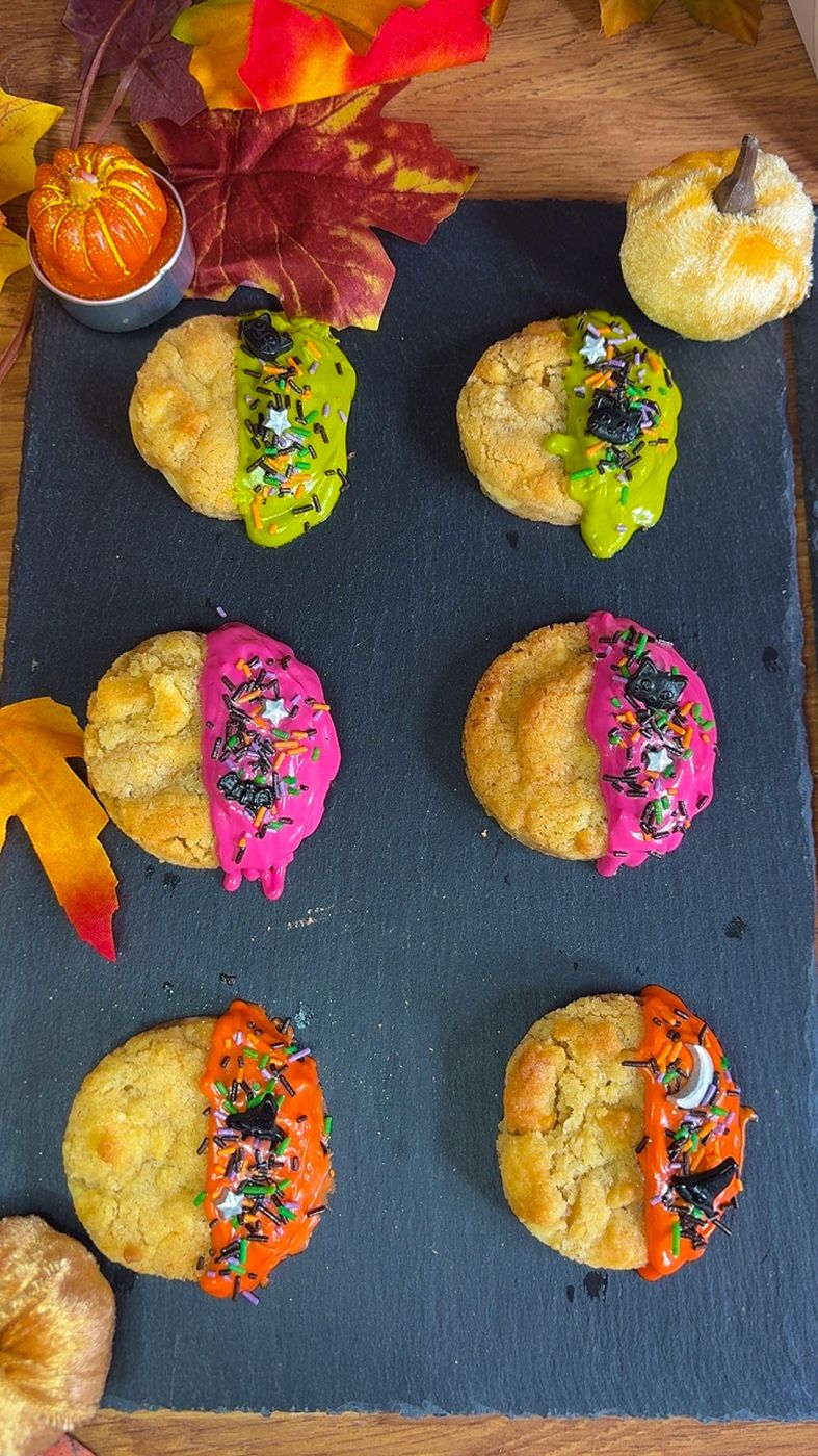 Halloween dipped chocolate chip cookies in pink, orange and green with Halloween sprinkles