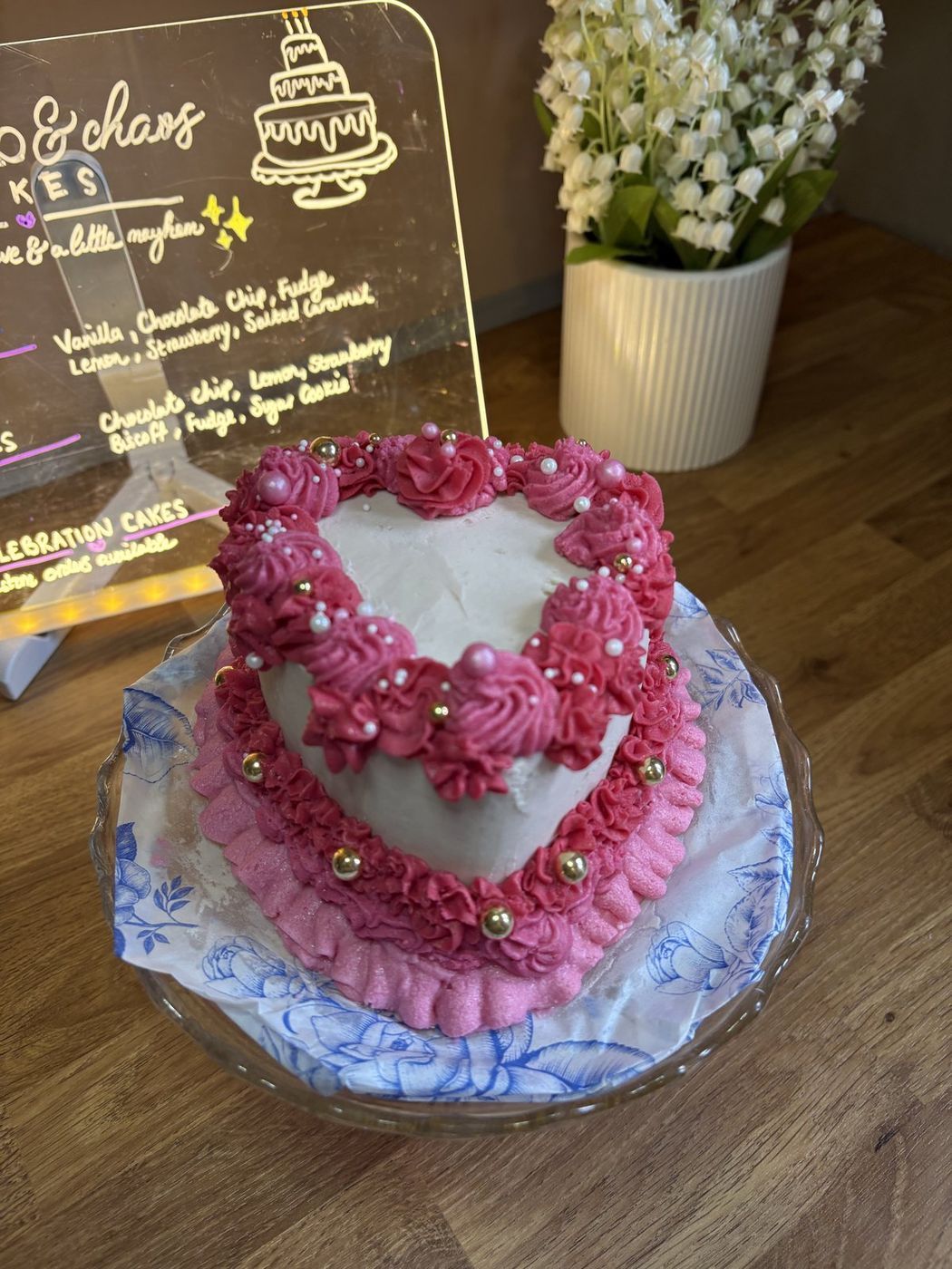 Heart-shaped cake with pink buttercream roses and gold pearls