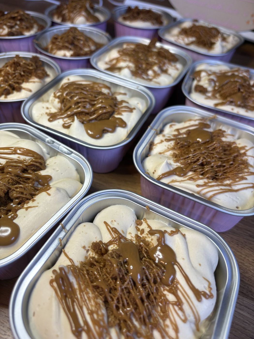Individual Biscoff cheesecakes with caramel drizzle and biscuit crumb