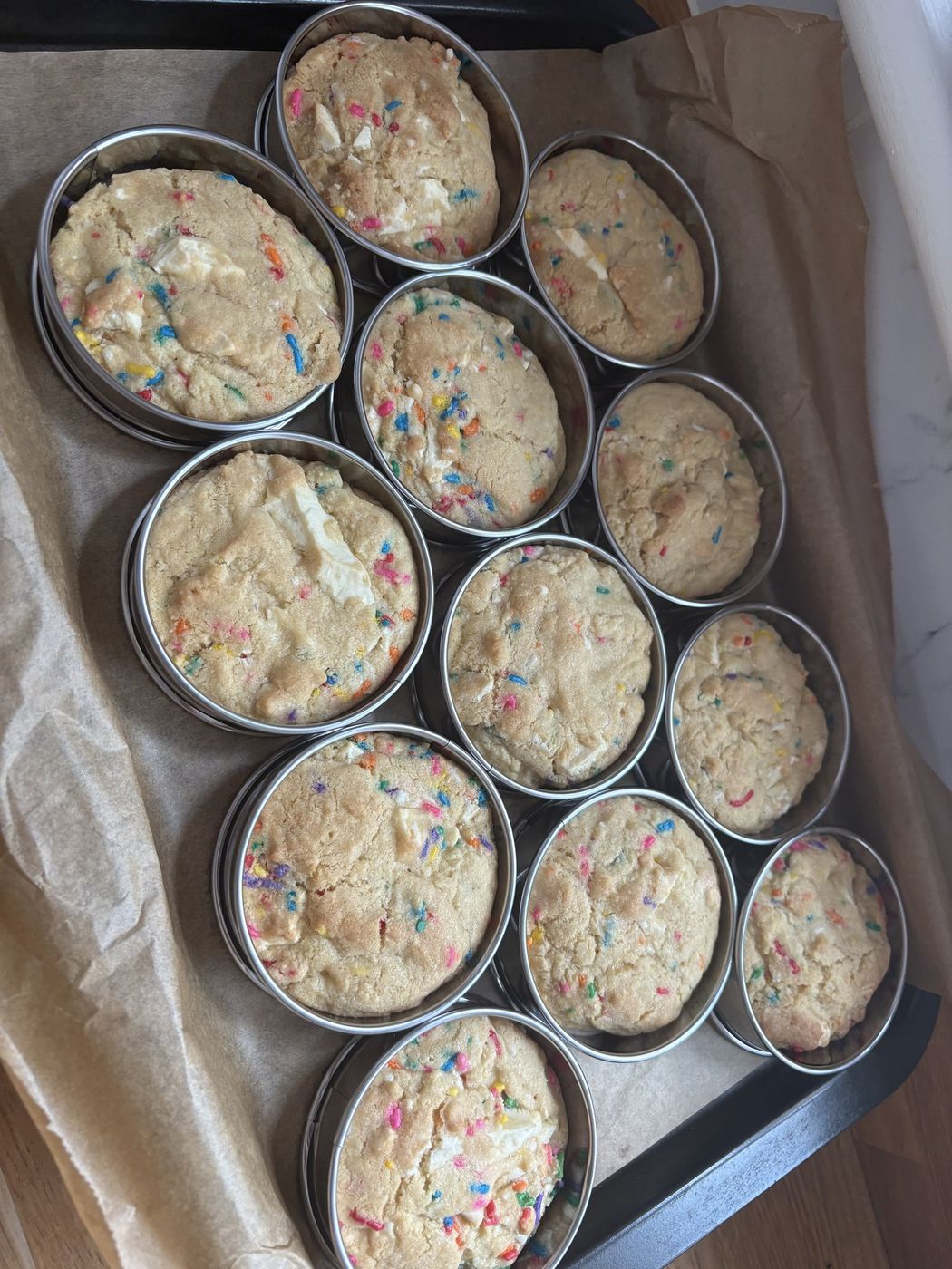 Freshly baked confetti sprinkle cookies cooling in rings