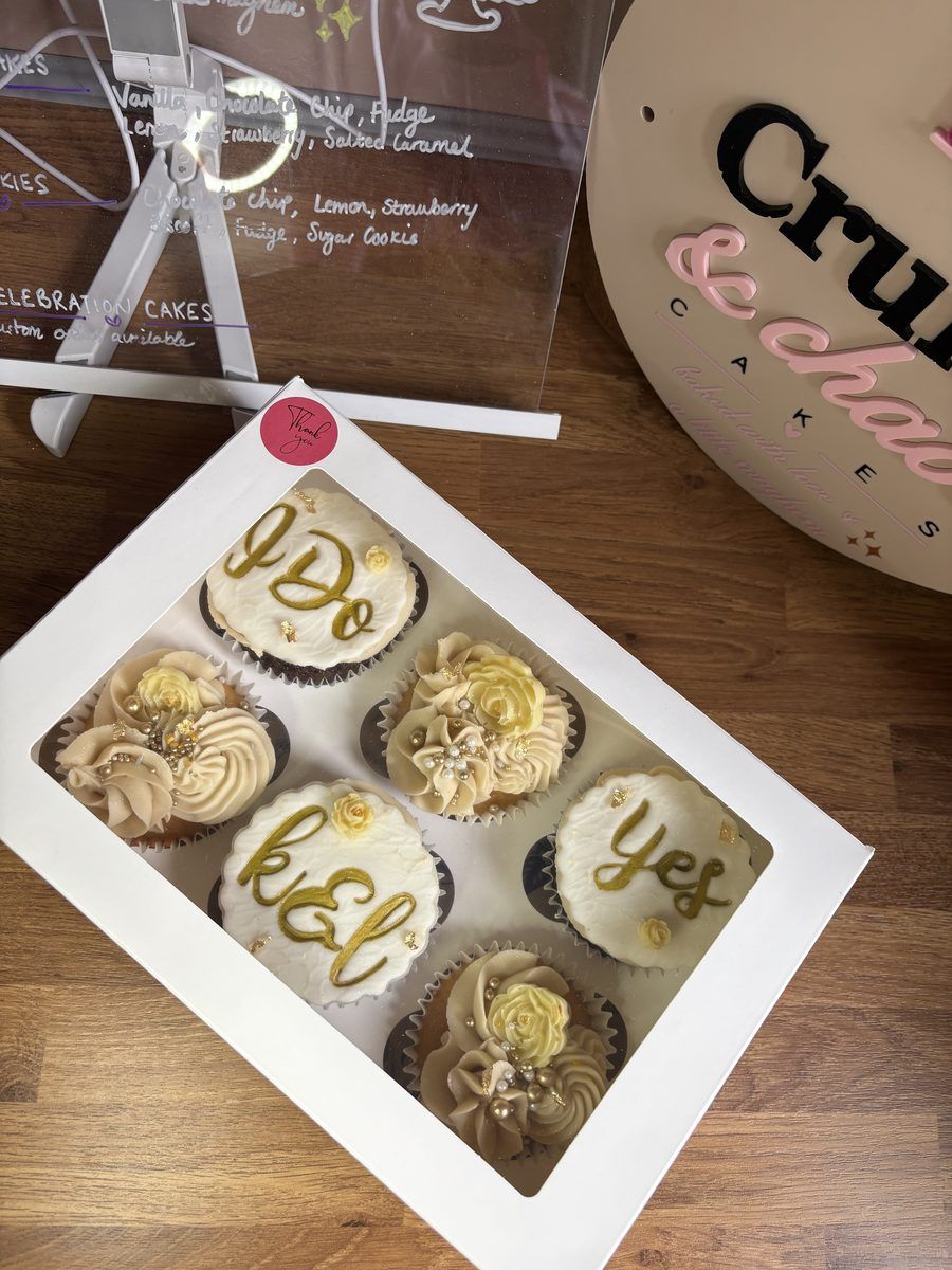 Box of cream and gold cupcakes with custom lettering