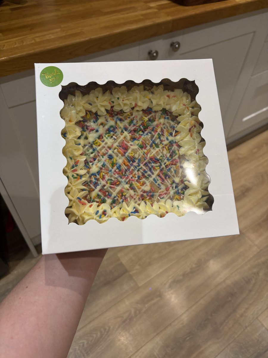 Loaded cookie slab with white icing and sprinkles