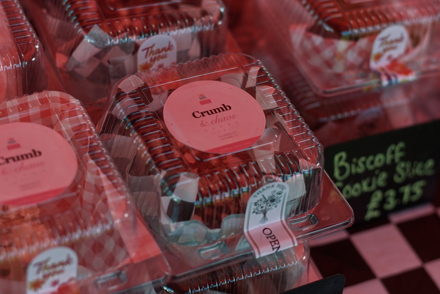Boxed traybake slices with Crumb & Chaos Cakes labels on the market stall