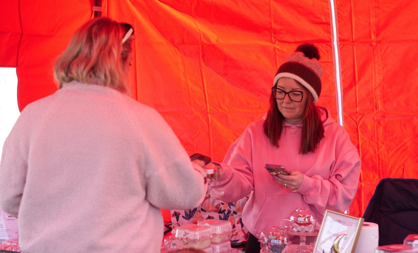 Lauren taking a card payment from a customer at the Crumb & Chaos Cakes market stall